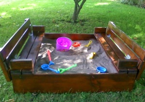 The sandbox complete, waiting for a little girl to come outside to the backyard and play.